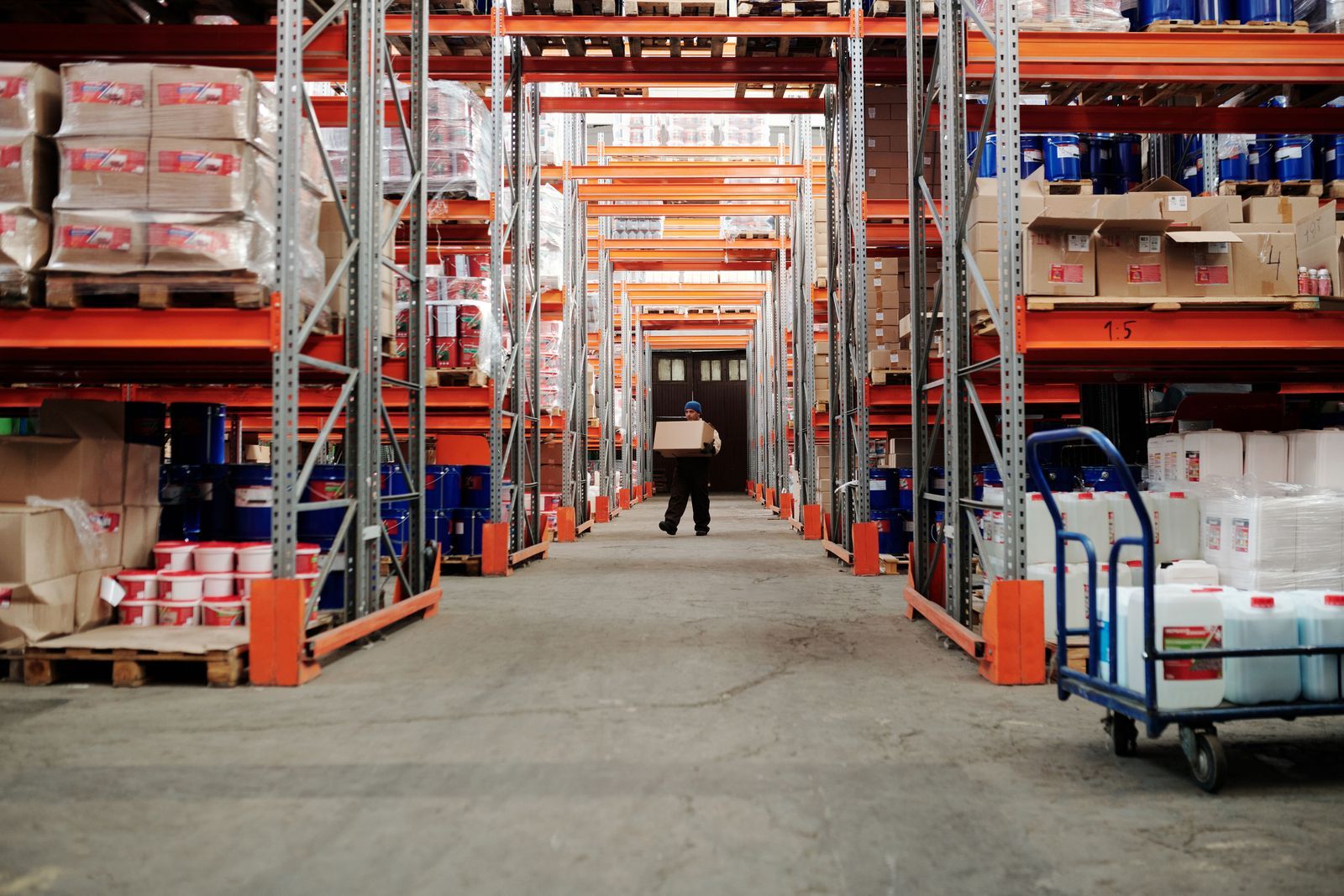 A warehouse aisle with high shelving stacked with cartons