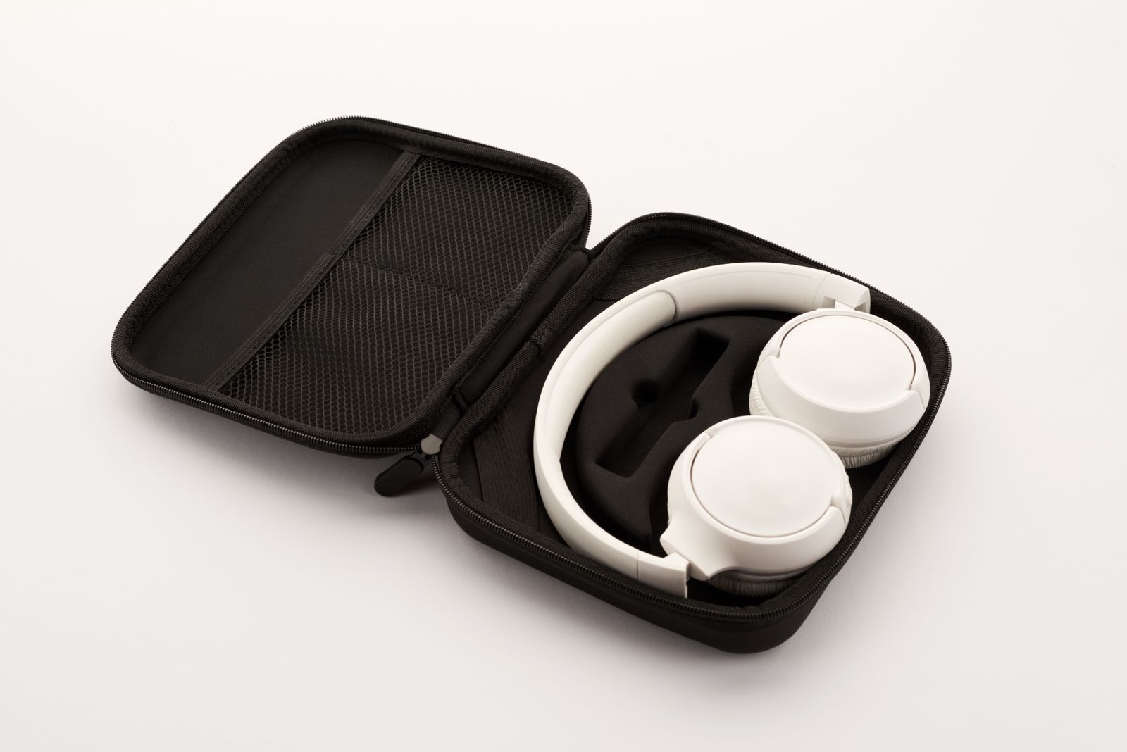 White wireless headphones beside their carry case