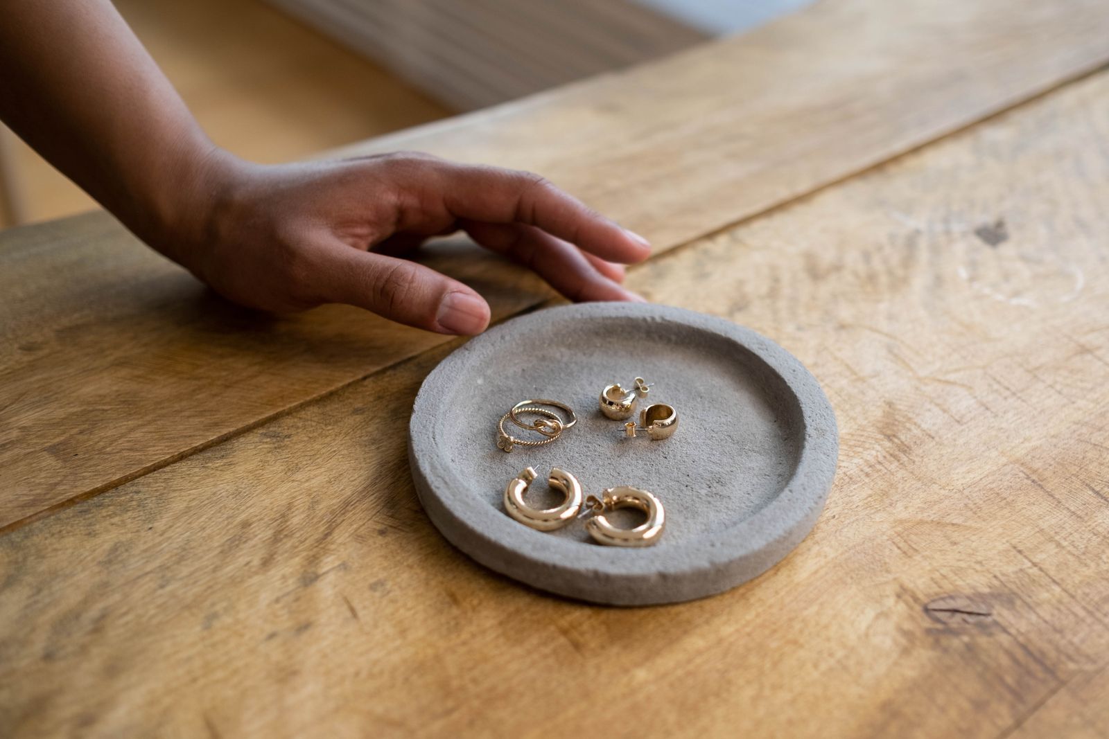 Gold rings and earrings on a stone dish