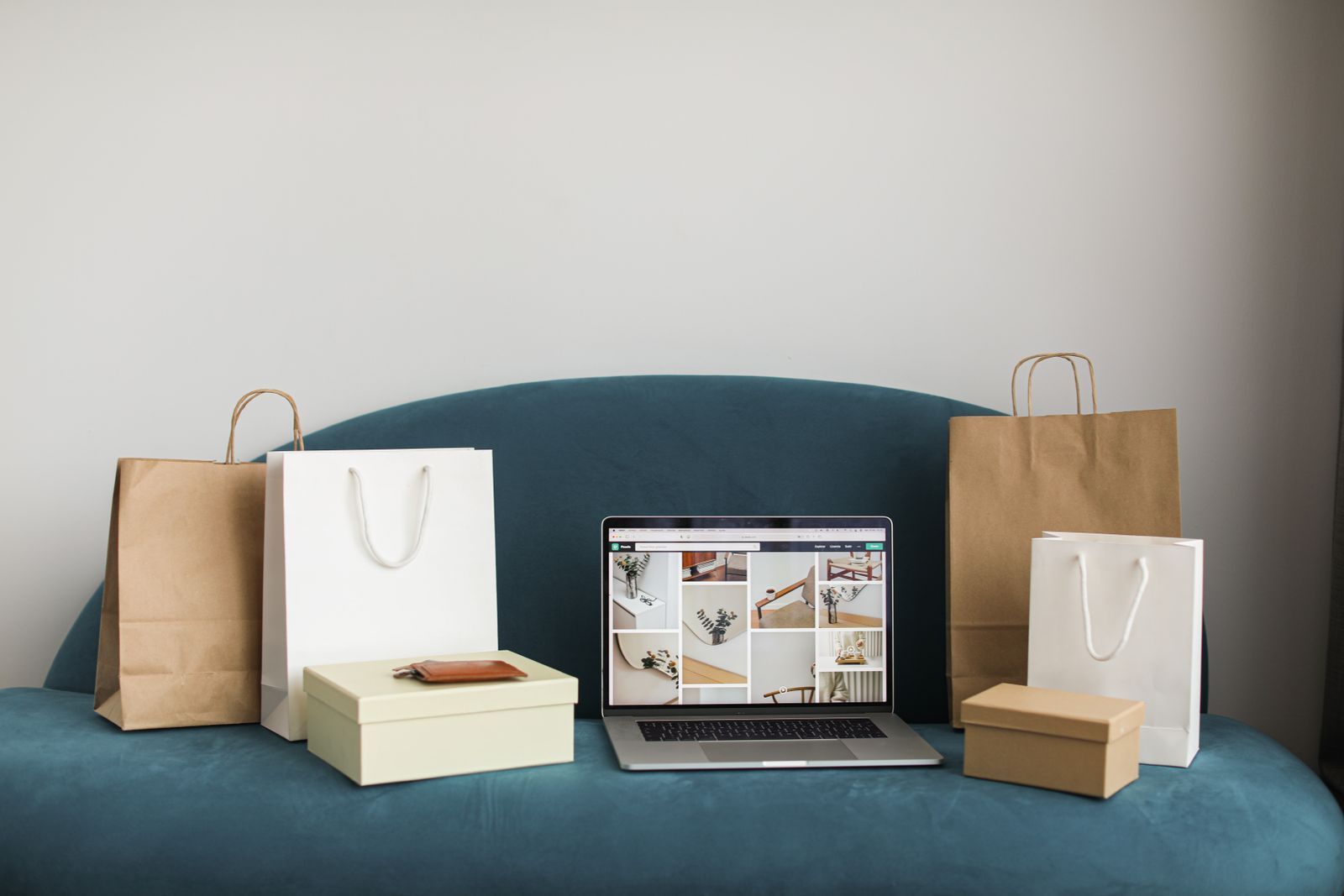 A laptop showing an online store beside shopping bags