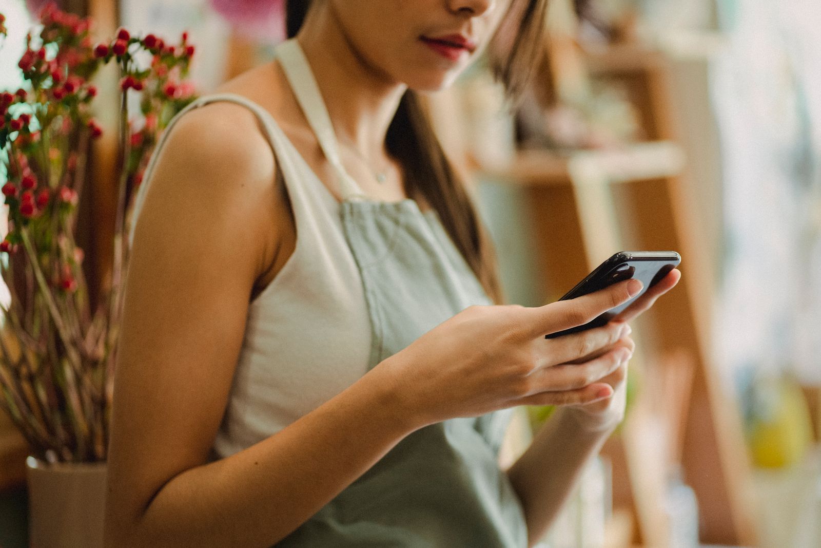A shop owner checking her phone at the counter