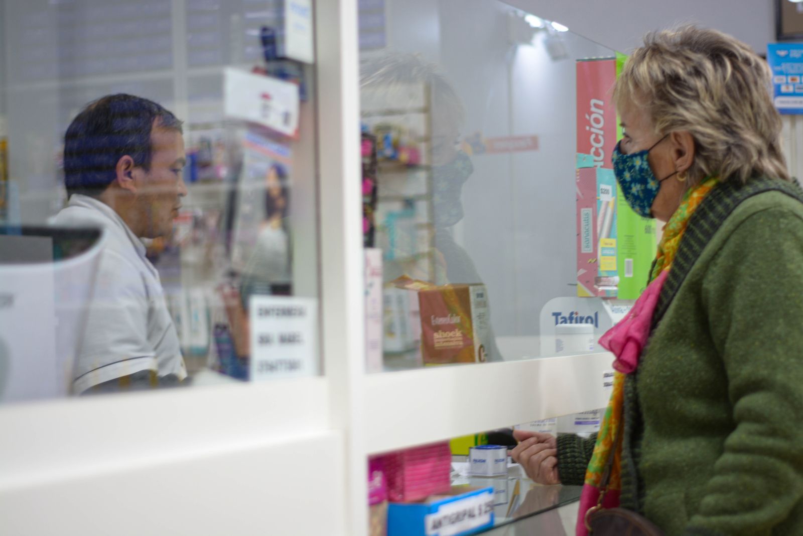 A customer speaking to a pharmacist at the counter