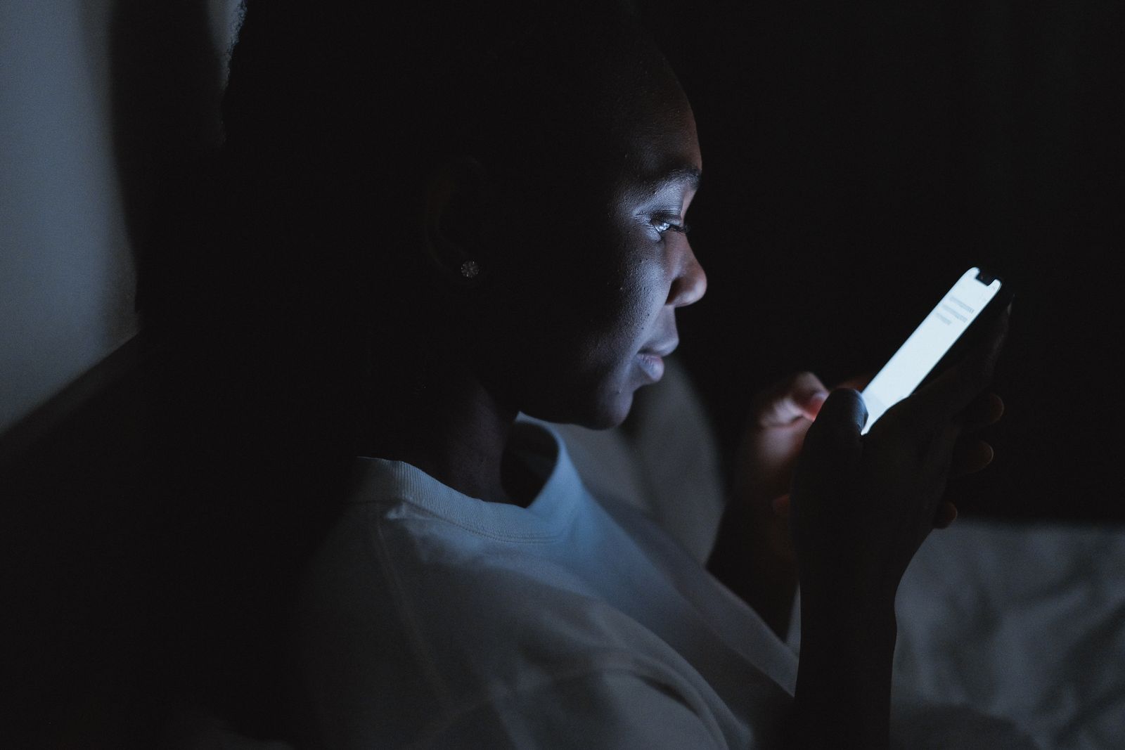 A woman reading her phone at night