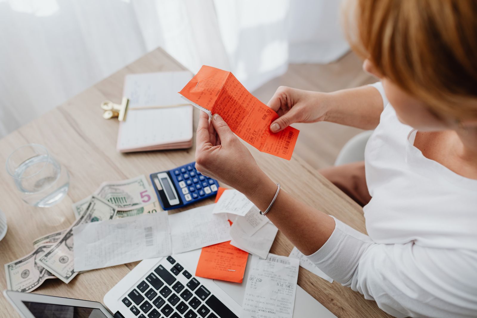 Receipts, a calculator and paperwork spread across a desk